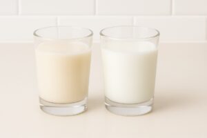 Side-by-side comparison of fresh goat milk and cow milk in clear glasses, highlighting subtle differences.