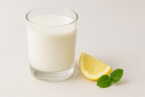 Tips for improving goat milk taste: showing a chilled glass of milk with optional citrus garnish.