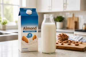 Unsweetened almond milk carton and glass on a bright kitchen counter for weight loss diet.