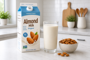 Fresh almond milk poured into a glass on a clean kitchen counter.